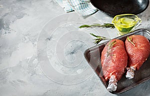 Pork fillet wrapped in bacon on concrete background. Closeup