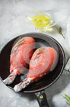 Pork fillet wrapped in bacon on concrete background.