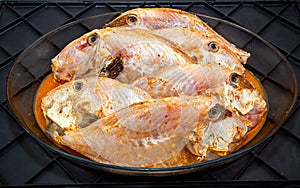 Pork fish or peroÃÂ¡ fish (Balistidae) cleaned and seasoned on a plate in top view photo