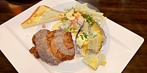 Pork grill steak menu set has baked potato with butter with vegetable salad