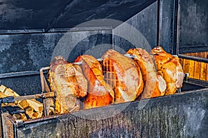 Pork ham meat is roasted on an open fire in the grill. Street Czech food. Prague, Czech Republic.