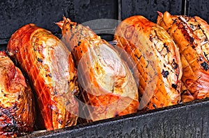 Pork ham meat is roasted on an open fire in the grill. Street Czech food. Prague, Czech Republic.