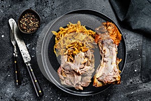 Pork leg eisbein with braised cabbage. Black background. Top view