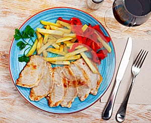 Pork loin with fried potato and pimiento on plate