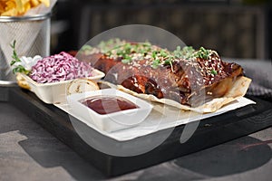 Pork loin ribs served on chopping board, potato