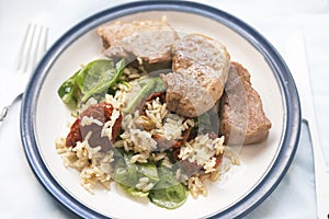 Pork loin with rice, spinach and sun dried tomatoes