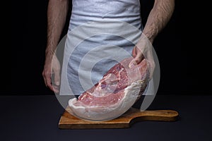 Pork meat on a black background. Raw pork leg. Fresh raw meat.