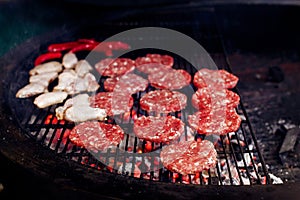 Pork meat and chicken grilling for burgers with flames and smoke