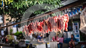 Pork meat is cut into pieces and hung on a wire and then dried in the sun before being fried and sold again, called sun-dried pork