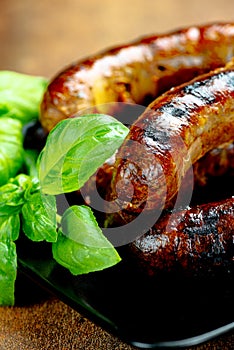 Pork meat sausages on a black plate