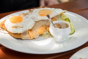 Pork meat Schnitzel Hamburg style with fried eggs, potato cucumber salad and Bavarian sweet mustard in Biergarten restaurant photo