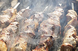 Pork meat (shashlik) baked on fire with smoke