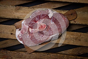 Pork meat on a wooden background. Raw pork leg.
