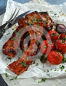 Pork middle chop roast with sweet and sour souce, baked tomatoes and red onion
