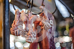 Pork patties hang on iron hooks at a pork shop in Ban Na Kluea Fresh Market, Pattaya