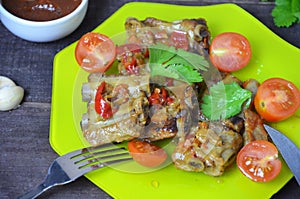 Pork ribs braised with soy sauce and vegetable tomato on the plate