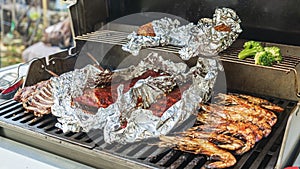 Pork ribs with grilled corn, shrimp, cauliflower and rack of lamb in barbecue. American food. View from above.