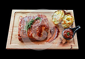 pork ribs and potato on plate on black