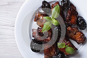 Pork ribs stewed with prunes closeup. horizontal top view