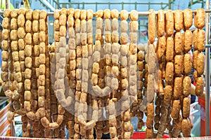 Pork and rice sausage or fermented hot dog northeastern isan thai style hanging in hawker stall for sale