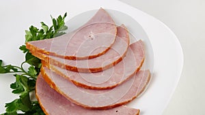 Pork roast ham with parsley.Ham on a white plate.