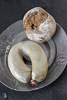 PorkÂ´s liver sausage and bread roll on pewter plate