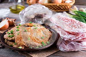 Pork schnitzel in a plate and frozen pork neck chops meat