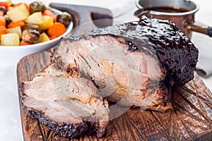 Pork shoulder in honey parmesan and soy souse, prepared in slow cooker or crockpot, on  wooden board, horizontal photo