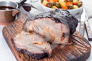 Pork shoulder in honey parmesan and soy souse, prepared in slow cooker or crockpot, on wooden board, horizontal photo