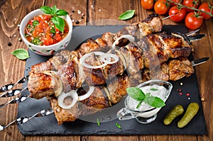 Pork skewers with onions on a wooden table