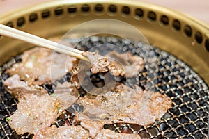 Pork slice steak cooking over charcoal grill.