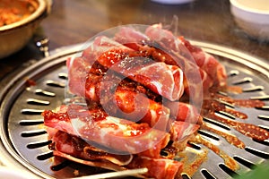 Pork slides A lot of placed on a stainless steel stove There is smoke from the heat floating up.