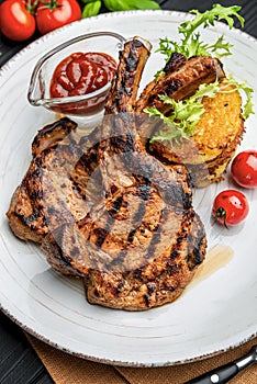 Pork steak with bone and potato pancakes