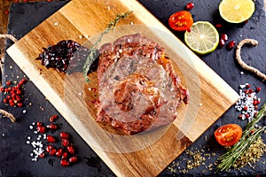 Pork steak with hot pepper and sauce on a cutting board