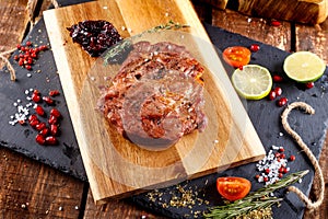 Pork steak with hot pepper and sauce on a cutting board