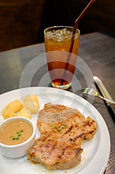 Pork steak with pepper sauce served with hash brown potato on wh