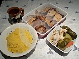 Pork steak, polenta, boiled wine, pickles, sausages