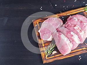 Pork steak, raw carbonate fillet on dark background, meat with r