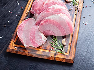 Pork steak, raw carbonate fillet on dark background, meat with r