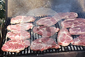 The pork steaks squeak on the grill