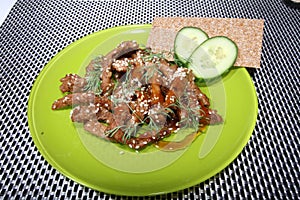 Pork in teriyaki sauce with slices of cucumber with cucumber slices and bread photo