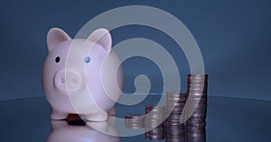 A porky bank with coins on a grey background.