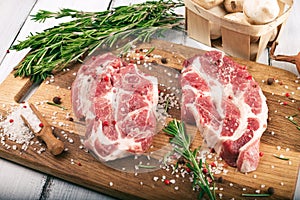 Porky steak with spice and herb on wood background