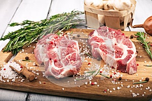 Porky steak with spice and herb on wood background