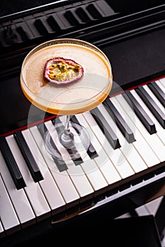 Pornstar Martini cocktail garnished with half of a passionfruit on a piano