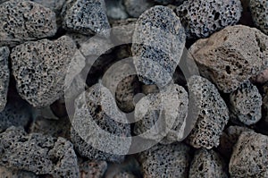 Porous black volcanic rock. Lava stone, pumice stone, or volcanic pumice with distinctive pores