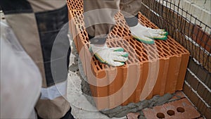 Porous ceramic blocks texture background. Worker puts a red ceramic block