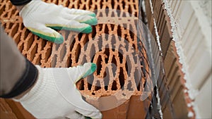 Porous ceramic blocks texture background. Worker puts a red ceramic block