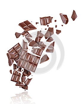 Porous chocolate broken into many pieces in the air, isolated on a white background