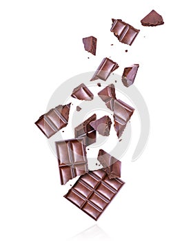 Porous dark chocolate crushed in the air on a white background